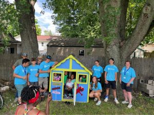 a group delivering a playhouse that they built and decorated for a Habitat for Humanity home.